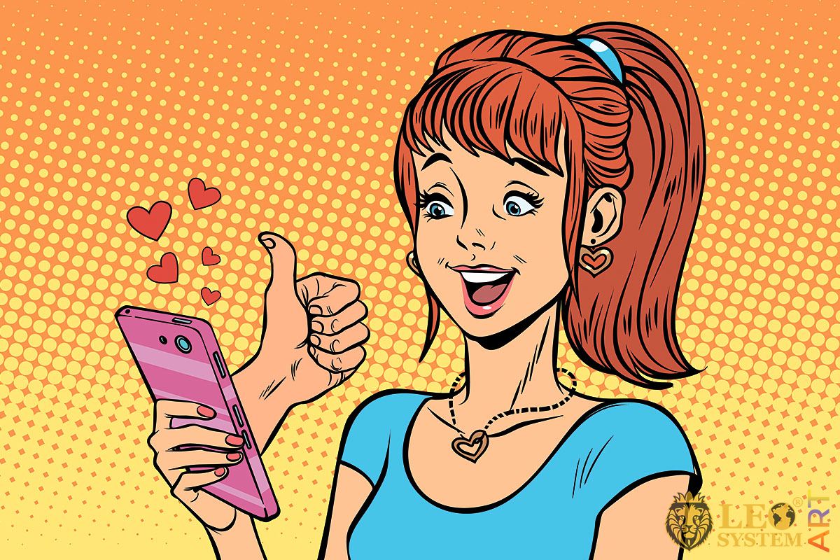 Cheerful girl with a pink mobile phone in her hands